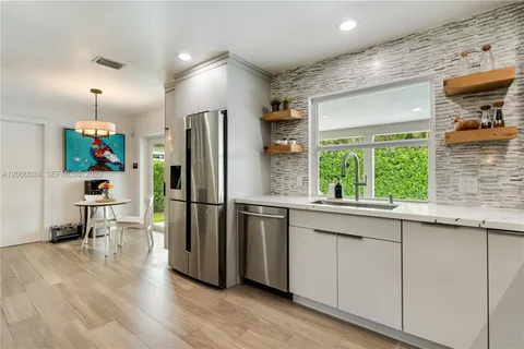 a dining room with furniture and a floor to ceiling window