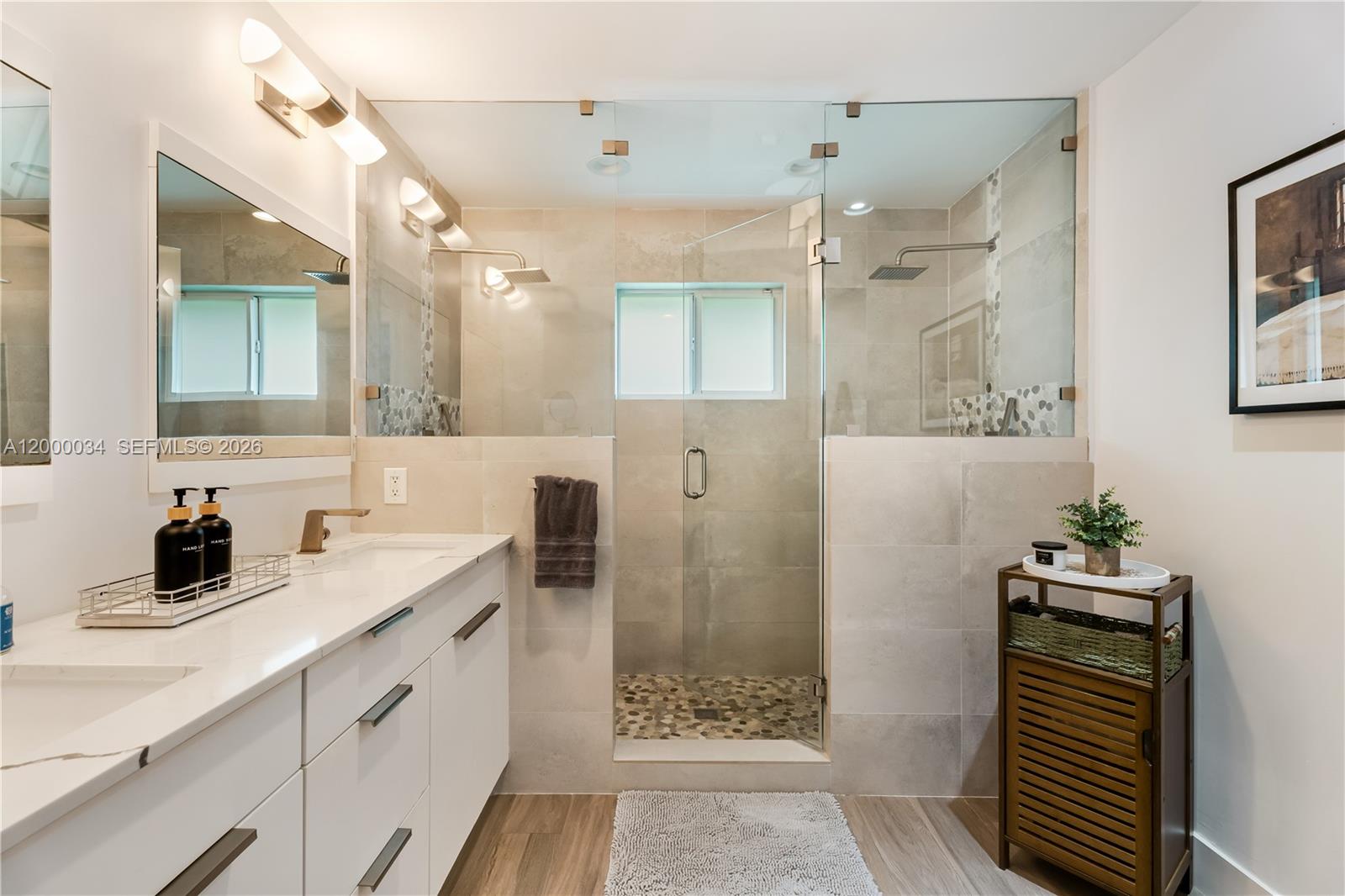 9511 Southwest 93rd Street Miami, FL 33176 - Photo 43 of 56 a bathroom with a double vanity sink a toilet a mirror and shower