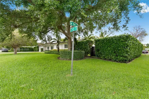 a view of house with a big yard and potted plants