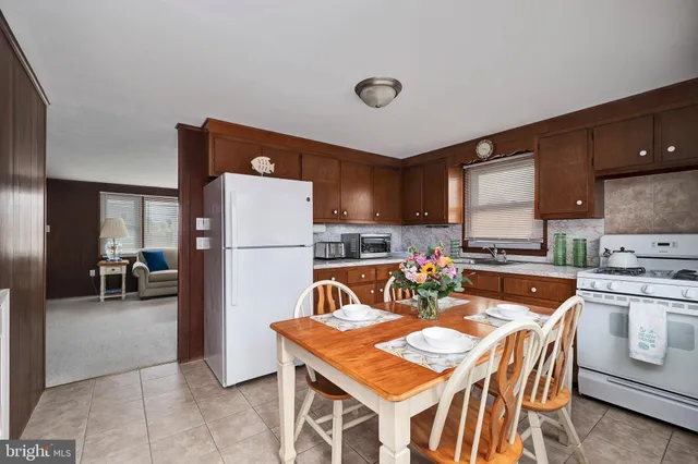 a kitchen with a refrigerator a stove a sink and a dining table