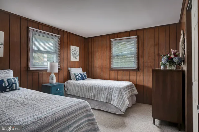 a bedroom with two beds and a dresser