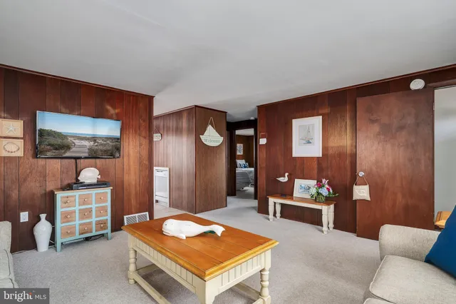 a living room with furniture a rug and kitchen view