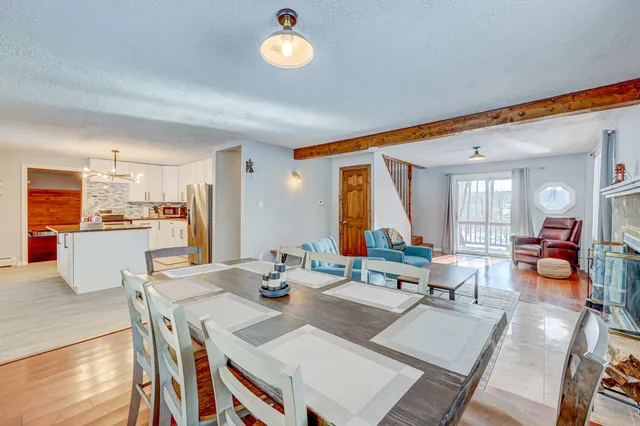 a living room with stainless steel appliances kitchen island granite countertop furniture and a large window