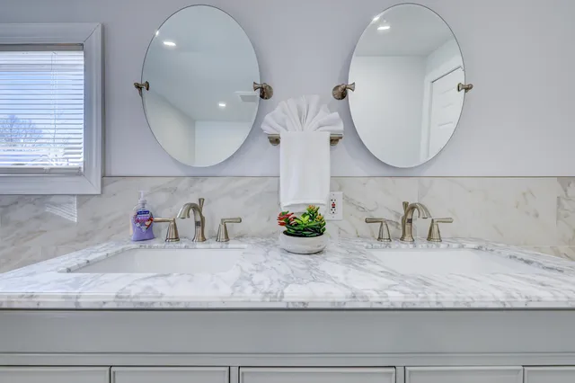 a bathroom with a granite countertop mirror and sink