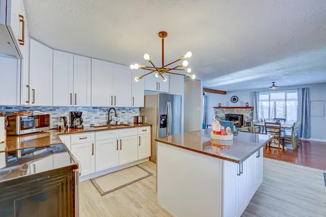 a kitchen with kitchen island granite countertop a sink cabinets and stainless steel appliances