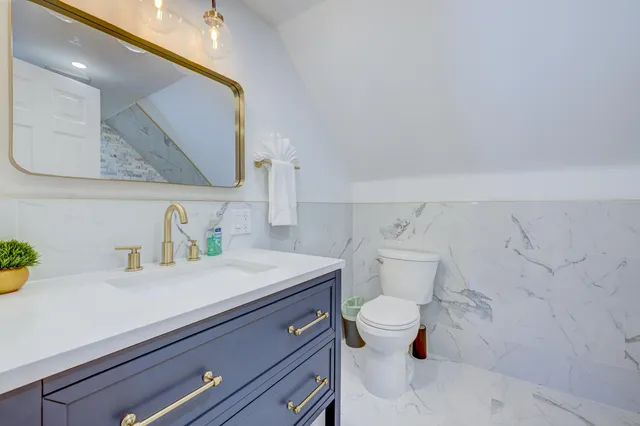 a bathroom with a sink a toilet and a mirror