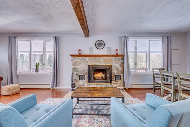 a living room with furniture a fireplace and a large window