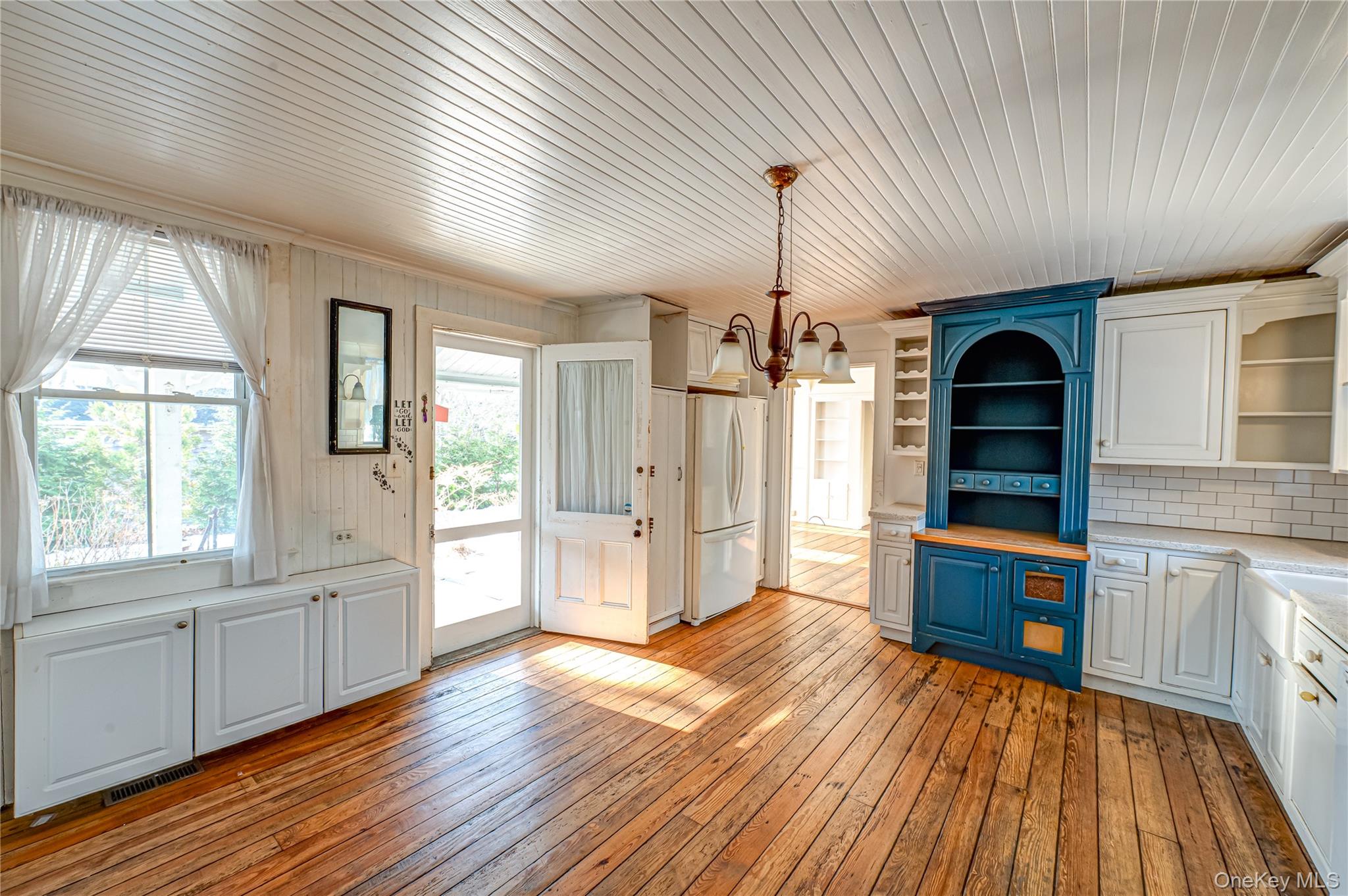179 G Springville Road Hampton Bays, NY 11946 - Photo 11 of 45 Kitchen with white cabinets, light wood-style floors, wood ceiling, a chandelier, and hanging light fixtures