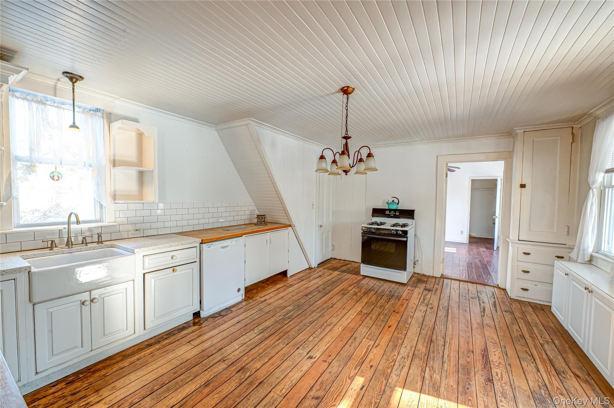 179 G Springville Road Hampton Bays, NY 11946 - Photo 13 of 45 Kitchen featuring white appliances, pendant lighting, light wood-style flooring, white cabinetry, and ornamental molding