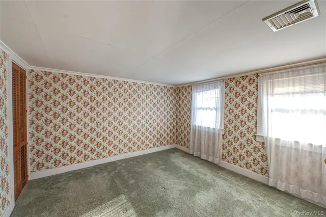 a view of a livingroom with a window and wooden floor