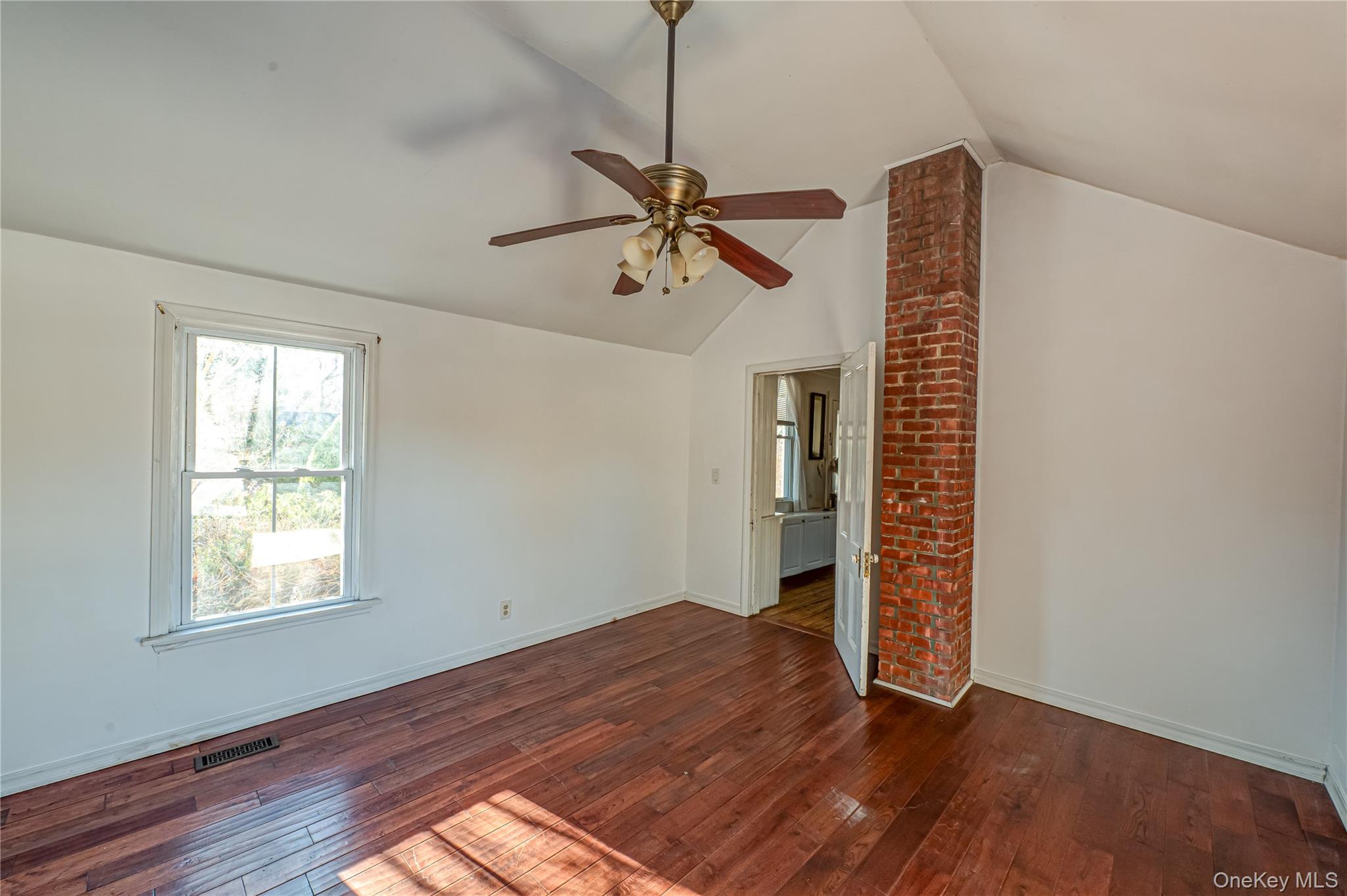 179 G Springville Road Hampton Bays, NY 11946 - Photo 28 of 45 Empty room featuring dark wood-style flooring, healthy amount of natural light, and lofted ceiling