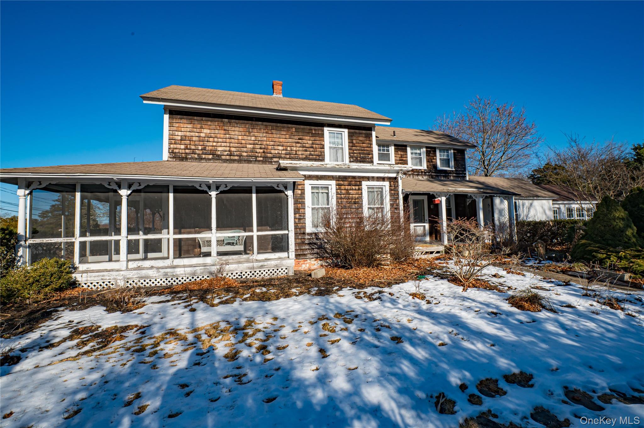 179 G Springville Road Hampton Bays, NY 11946 - Photo 30 of 45 Rear view of house featuring a chimney, roof with shingles, and a sunroom