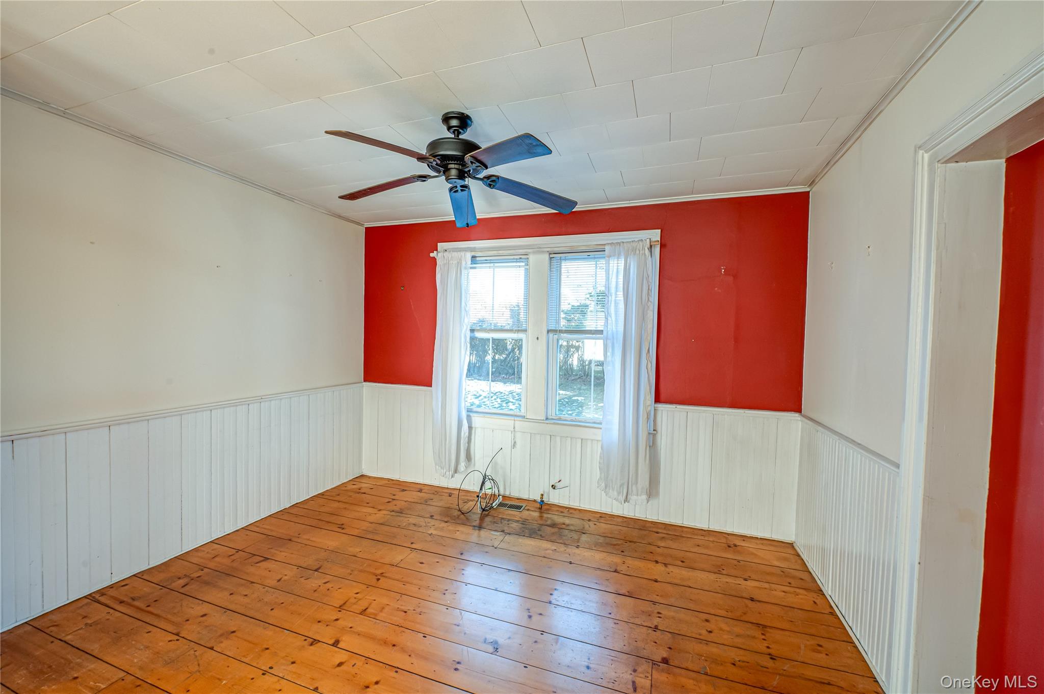 179 G Springville Road Hampton Bays, NY 11946 - Photo 8 of 45 Unfurnished room with hardwood / wood-style floors, ceiling fan, and wainscoting