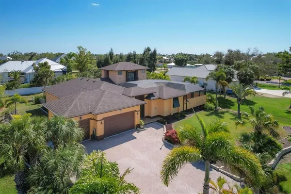 an aerial view of a house with a garden and lake view