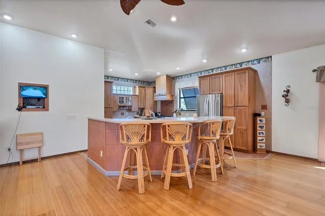 a kitchen with stainless steel appliances a dining table chairs and wooden floor