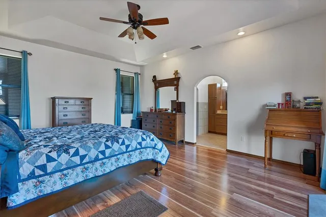 a bedroom with a bed a chandelier and a window