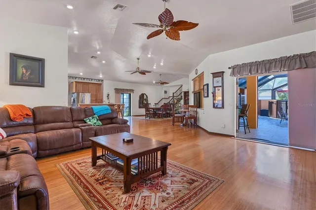 a living room with furniture a wooden floor and ceiling fan