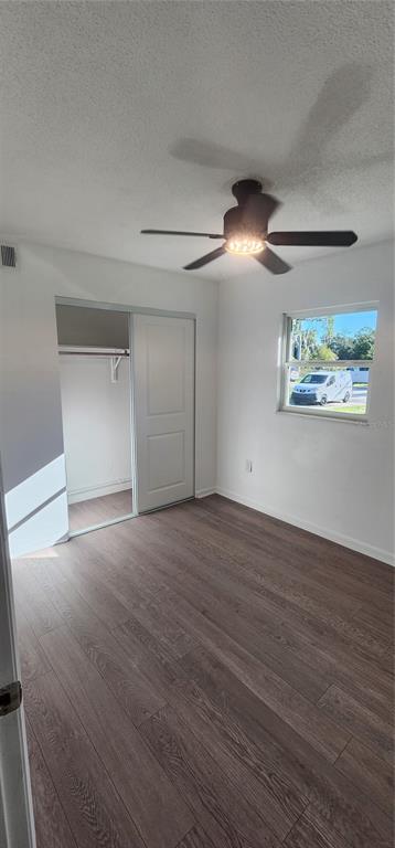 390 Clark Street Deltona, FL 32725 - Photo 7 of 10 an empty room with wooden floor chandelier fan and windows