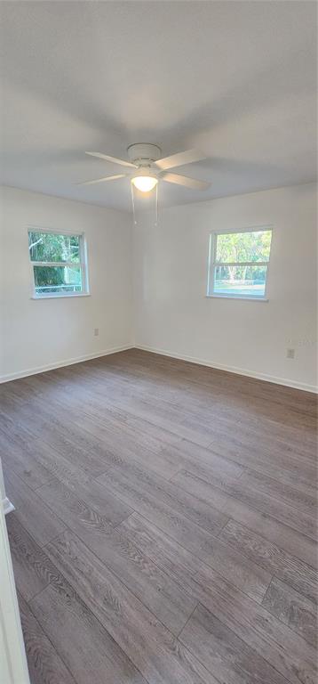 390 Clark Street Deltona, FL 32725 - Photo 9 of 10 a view of an empty room with wooden floor and a window