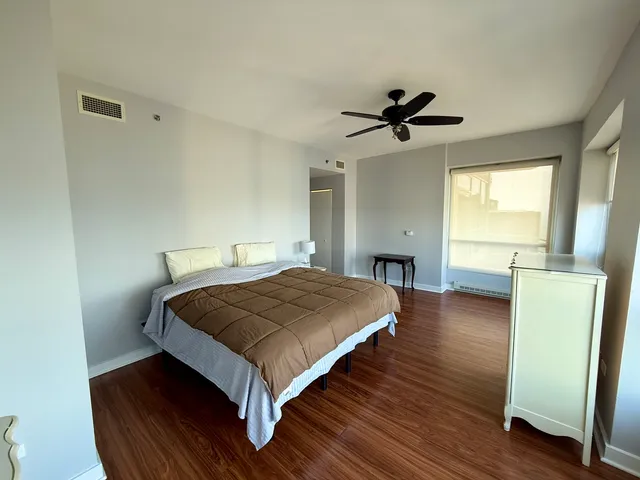 a bedroom with a bed and wooden floor