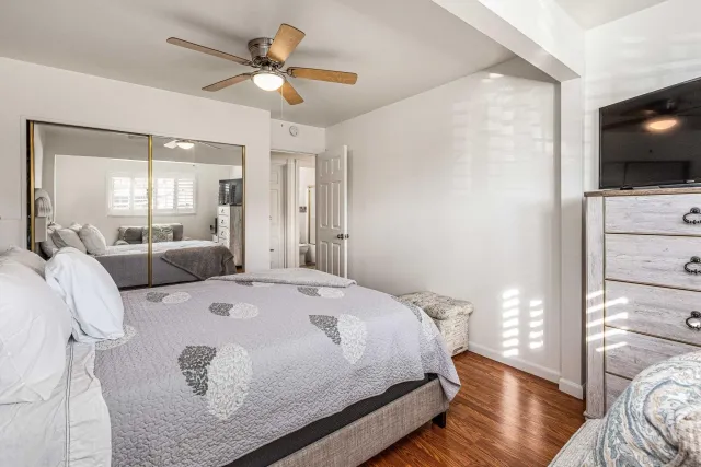 a spacious bedroom with a bed and a flat screen tv