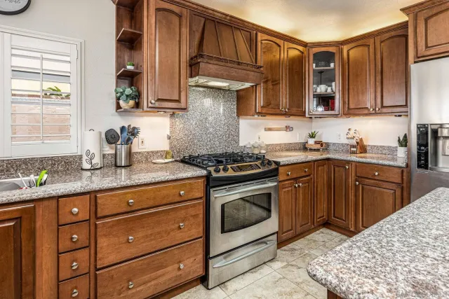 a kitchen with stainless steel appliances granite countertop a sink stove and cabinets