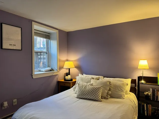 a large bed sitting in a bedroom next to a lamp