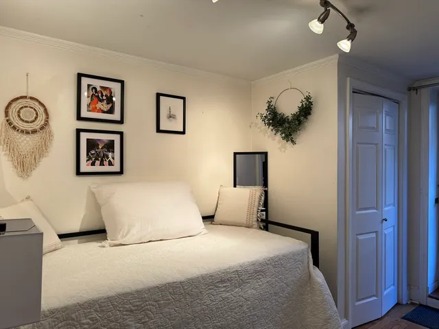 a bedroom with a large bed and a chandelier
