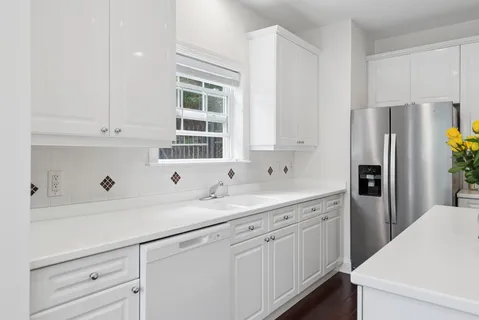 a kitchen with a sink dishwasher a refrigerator and cabinets