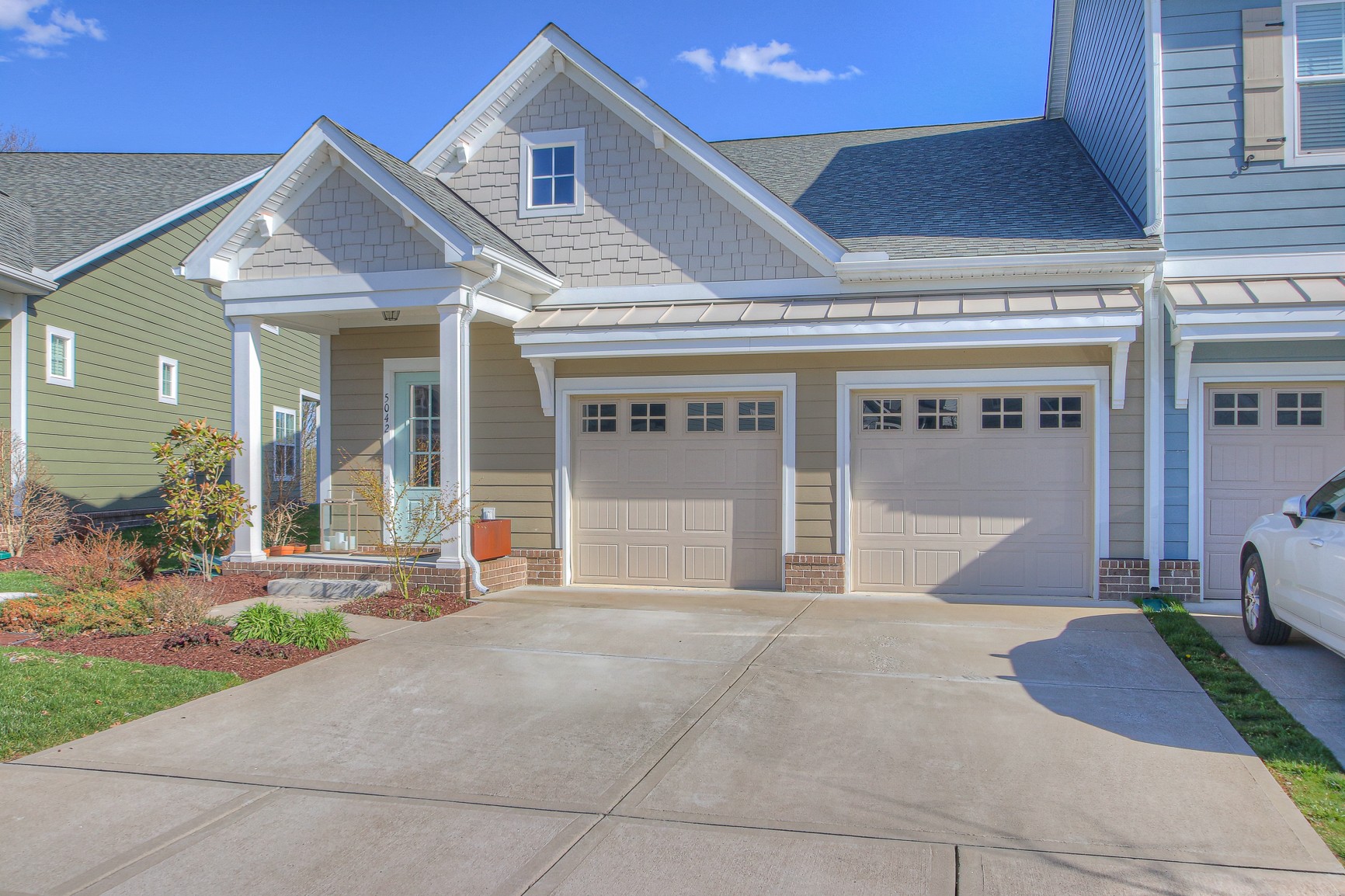 a front view of a house with a garden and plants