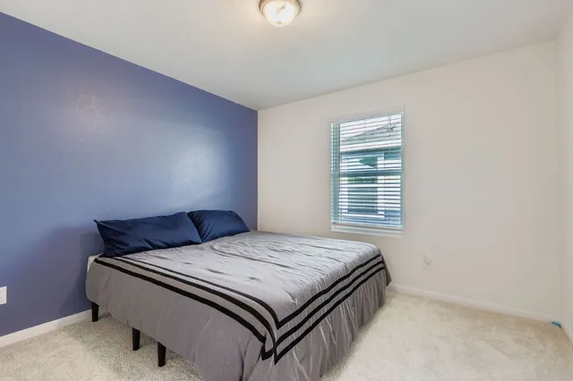 a bedroom with a bed and a window