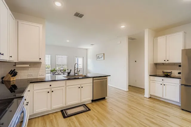 a kitchen with granite countertop a sink a stove and cabinets