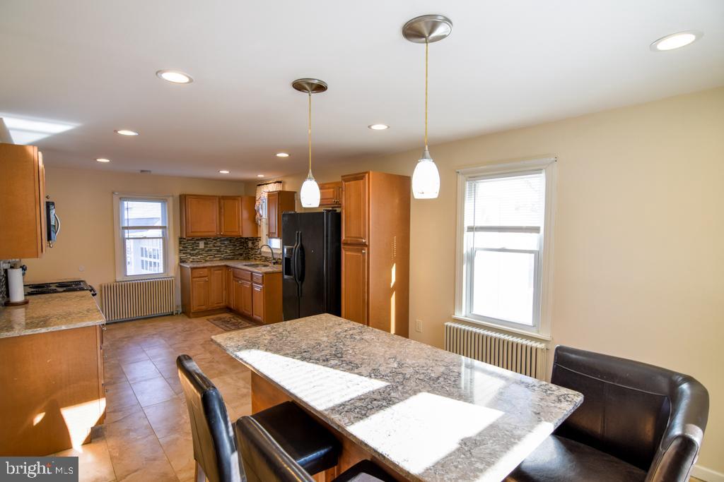 1071 West Bristol Road Warminster, PA 18974 - Photo 3 of 34 a kitchen with a refrigerator a sink dishwasher with a dining table and chairs
