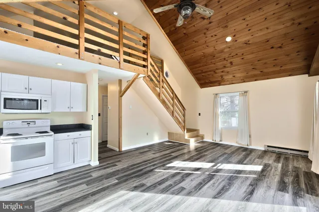 an aerial view of residential houses with outdoor space and lake view