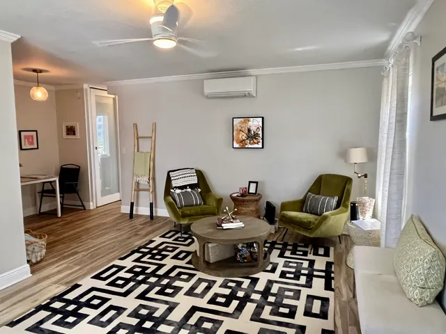a living room with furniture and wooden floor