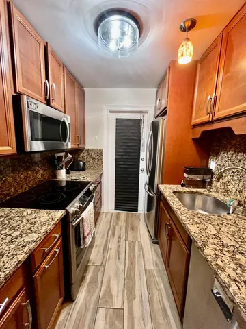 a kitchen with stainless steel appliances granite countertop a stove refrigerator and a microwave