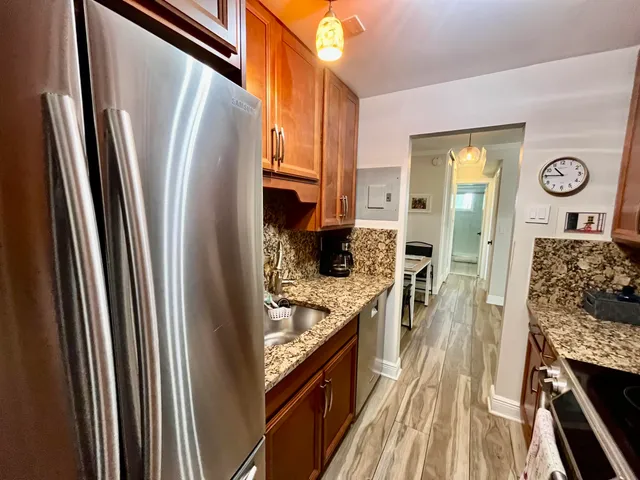 a kitchen with stainless steel appliances granite countertop a refrigerator and a stove