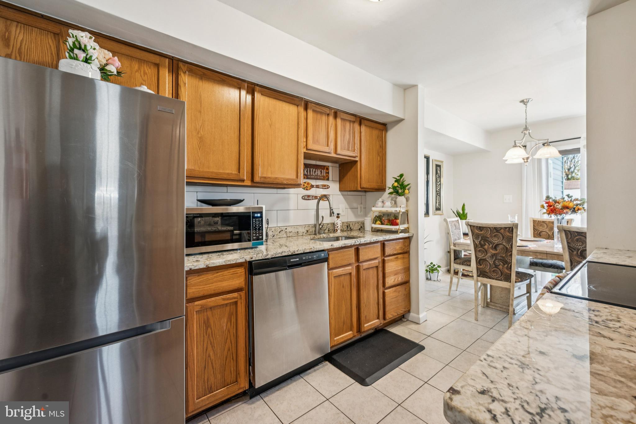 7 Lennox Court Sicklerville, NJ 08081 - Photo 17 of 25 a kitchen with stainless steel appliances granite countertop a refrigerator a stove a sink dishwasher and a dining table with wooden floor