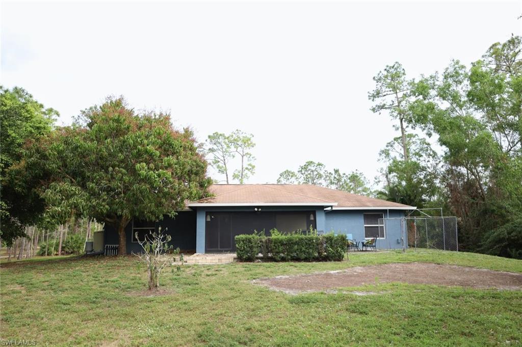 4295 14th Street Northeast Naples, FL 34120 - Photo 18 of 23 Rear view of house with a yard, a sunroom, and stucco siding