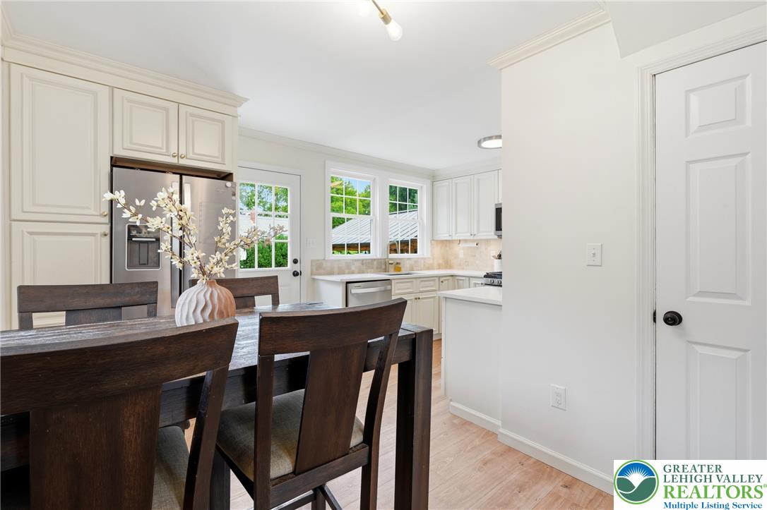 408 Maple Road Hellertown, PA 18055 - Photo 12 of 66 Gleaming hardwood floors and classic crown molding enrich this bright kitchen and dining space.