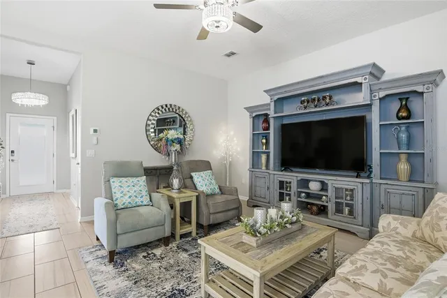 a living room with furniture a flat screen tv and a large window