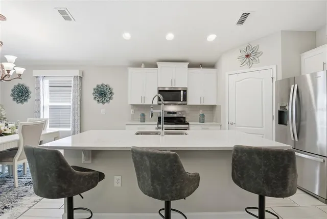 a kitchen with stainless steel appliances white cabinets and a stove top oven