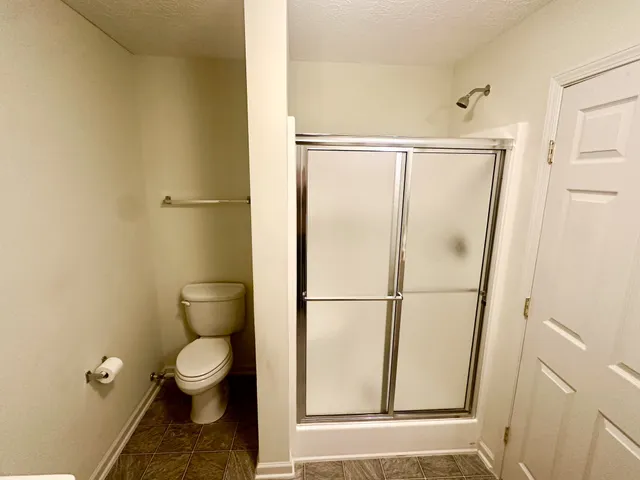 a bathroom with a toilet and a shower