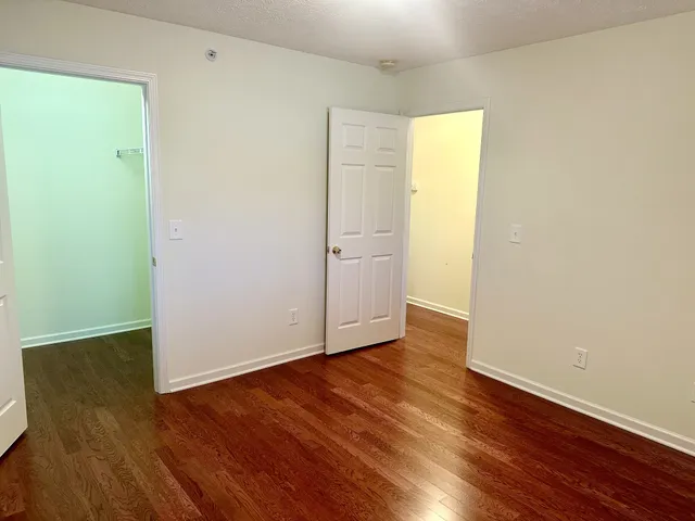 an empty room with wooden floor and closet