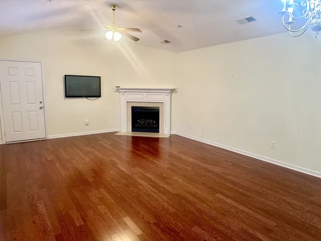a view of empty room with wooden floor and fireplace