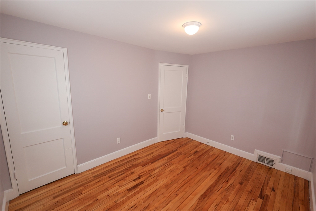 33 Paragon Road, Unit 1 Boston, MA 02132 - Photo 16 of 20 a view of an empty room with wooden floor