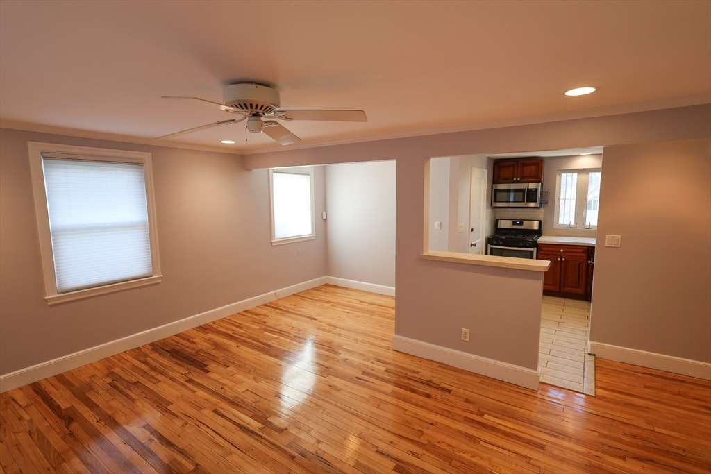 33 Paragon Road, Unit 1 Boston, MA 02132 - Photo 5 of 20 a view of a kitchen and an empty room with wooden floor and a kitchen