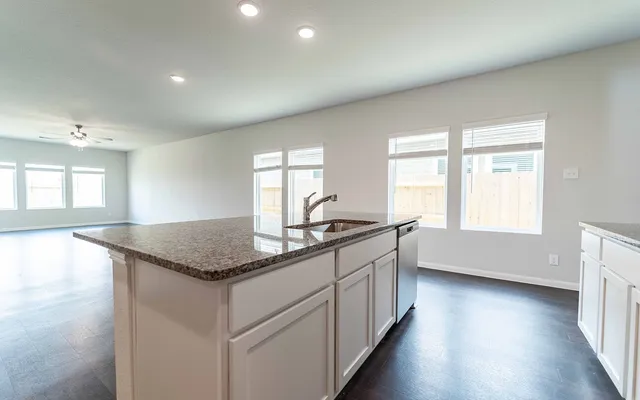 a kitchen with stainless steel appliances granite countertop a sink and a large window