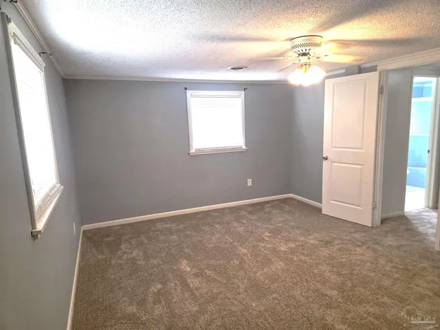 an empty room with closet and fan