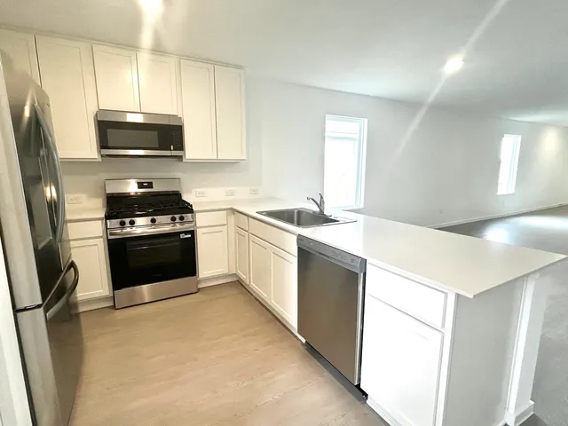 a kitchen with a sink a stove and a refrigerator